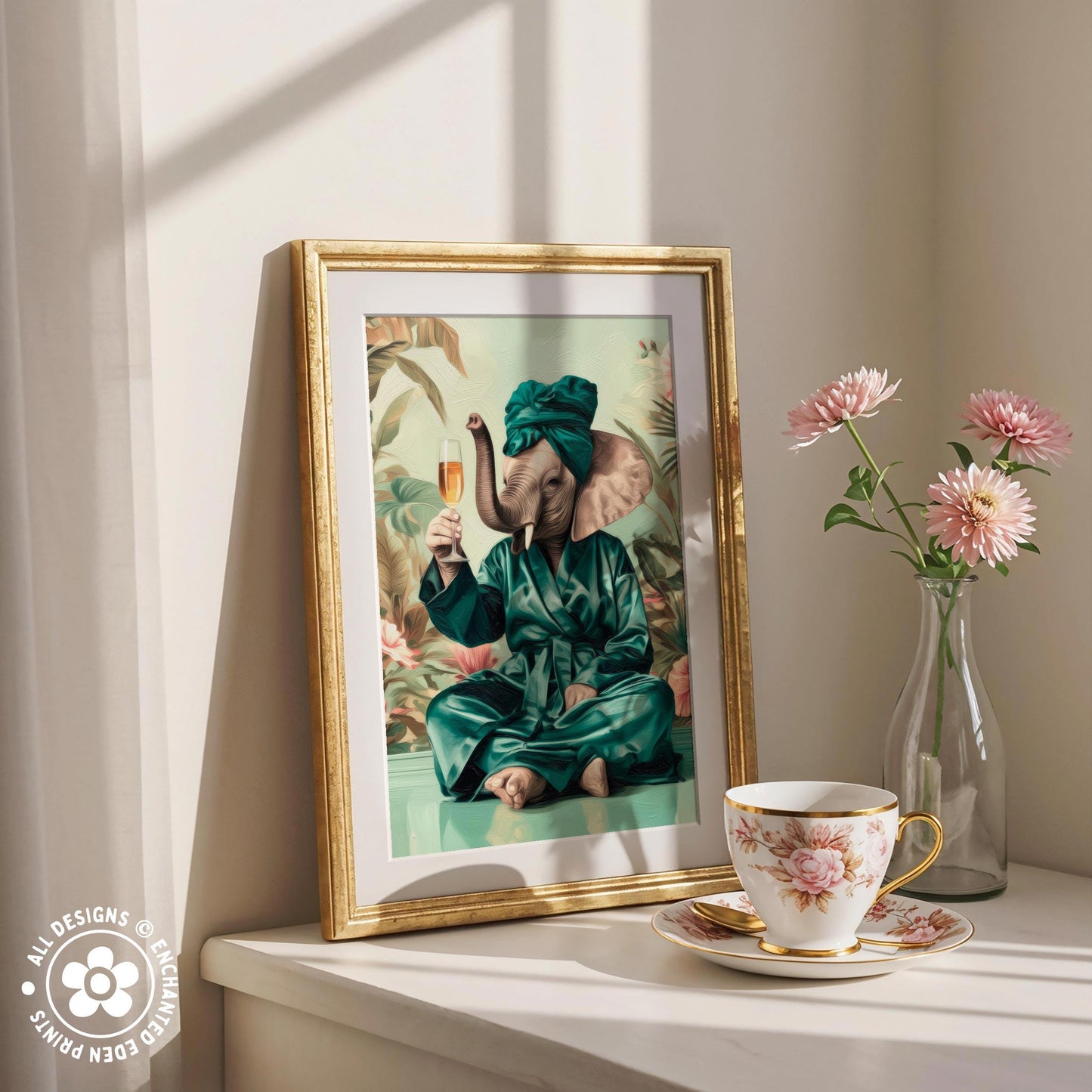 a framed painting of an elephant dressed in a green robe and holding a glass of champagne, sitting on a bench and holding a cup of tea. The painting is displayed on a white shelf, with a vase of pink flowers and a cup of tea nearby.