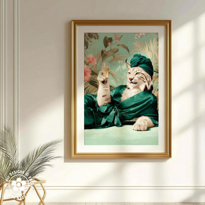 A framed image of a cat wearing a green robe and holding a glass of champagne, with a tropical floral background.
