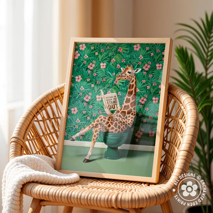 A framed illustration of a giraffe sitting on a green toilet, surrounded by a tropical floral background.