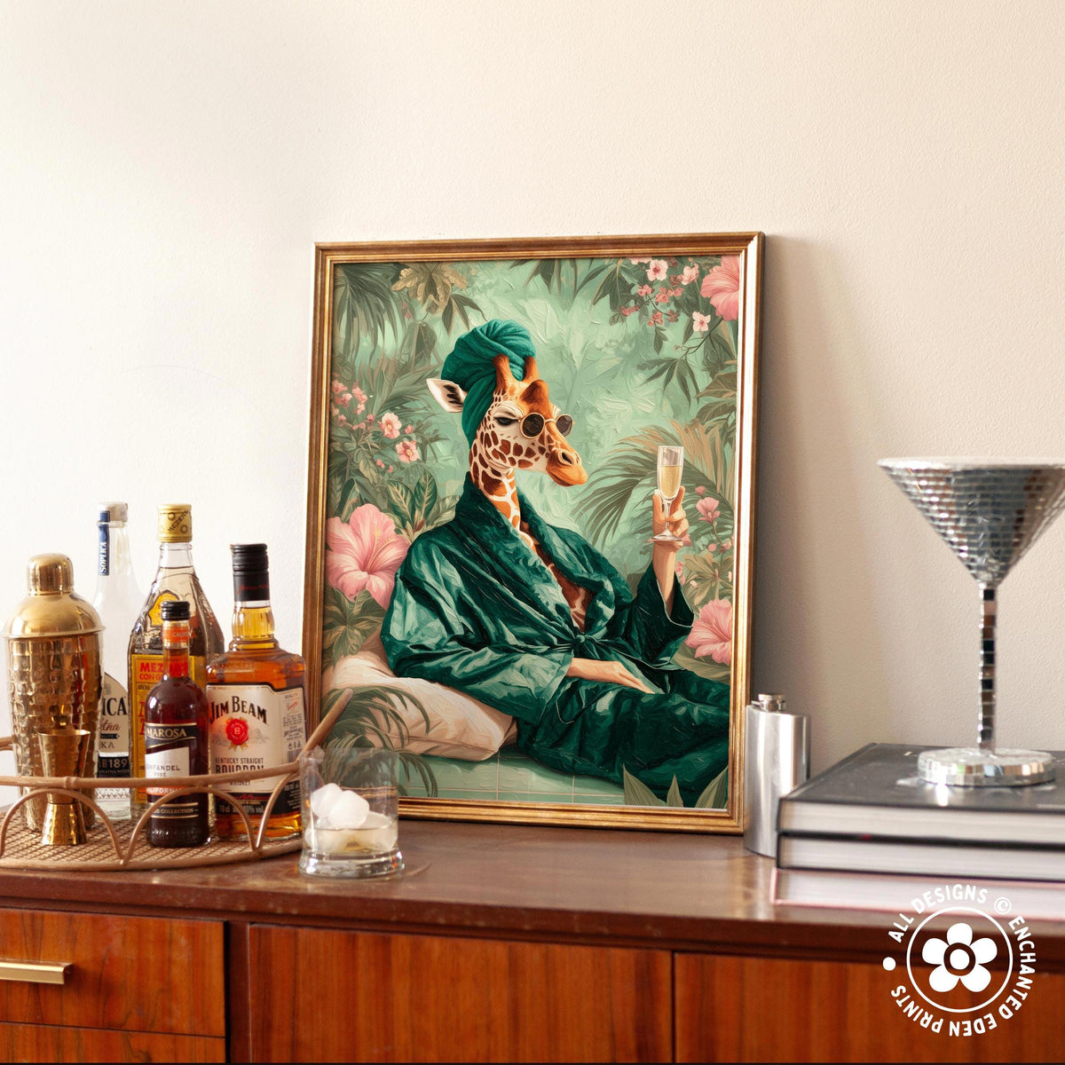 a framed painting of a giraffe wearing a green robe and holding a glass of champagne, surrounded by a tropical garden scene.