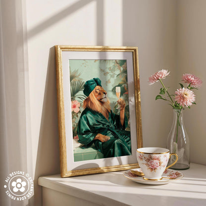 a framed painting of a lion wearing a green robe and holding a glass of wine, placed on a white shelf next to a vase of pink flowers and a cup of tea.