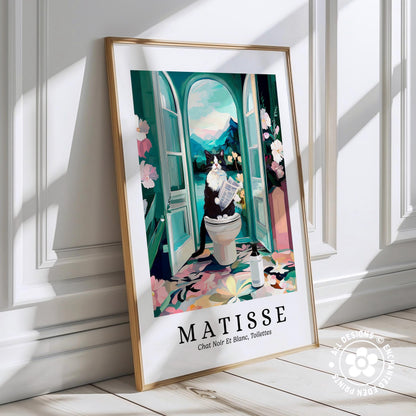The image is a framed poster depicting a cat sitting on a toilet in a bathroom, with a colorful and whimsical scene.