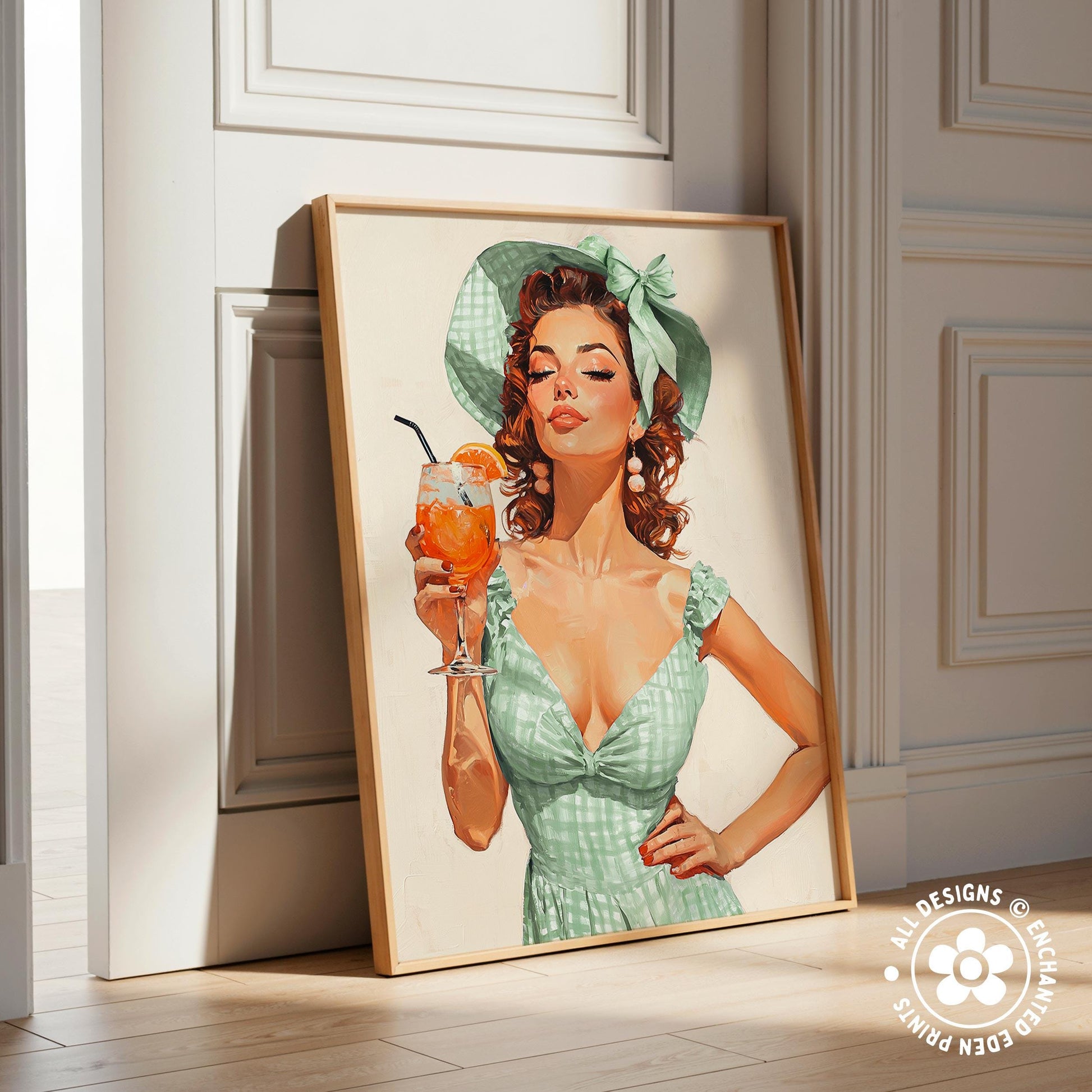 A framed illustration of a woman in a green dress holding a glass of orange juice.