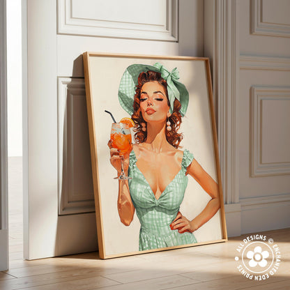 A framed illustration of a woman in a green dress holding a glass of orange juice.