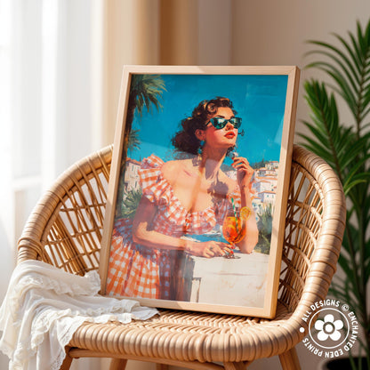 A framed painting of a woman in a red and white checkered dress, wearing sunglasses and holding a drink, is displayed on a wicker chair.