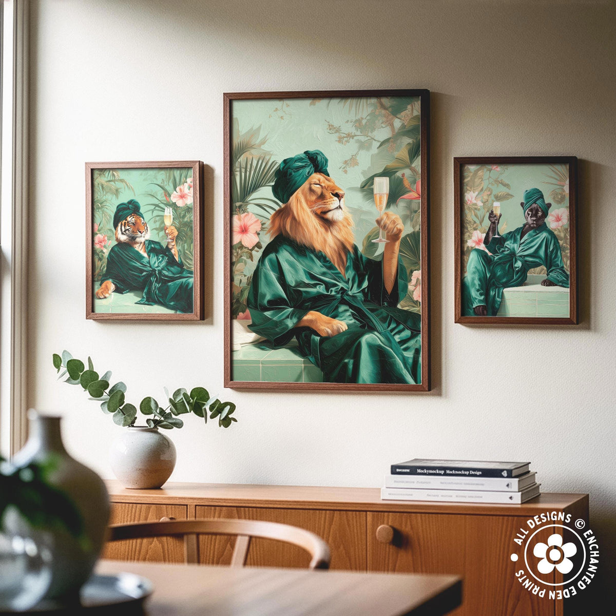a wooden cabinet with a vase of flowers and a stack of books on top. There are three framed paintings hanging on the wall above the cabinet, depicting a lion in a green robe holding a champagne glass.