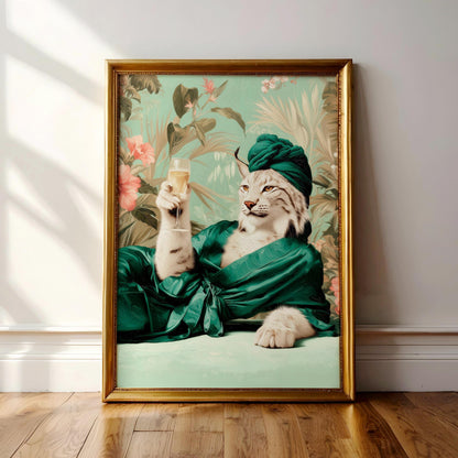 A framed image of a cat wearing a green robe and holding a glass of wine, with a tropical floral background.