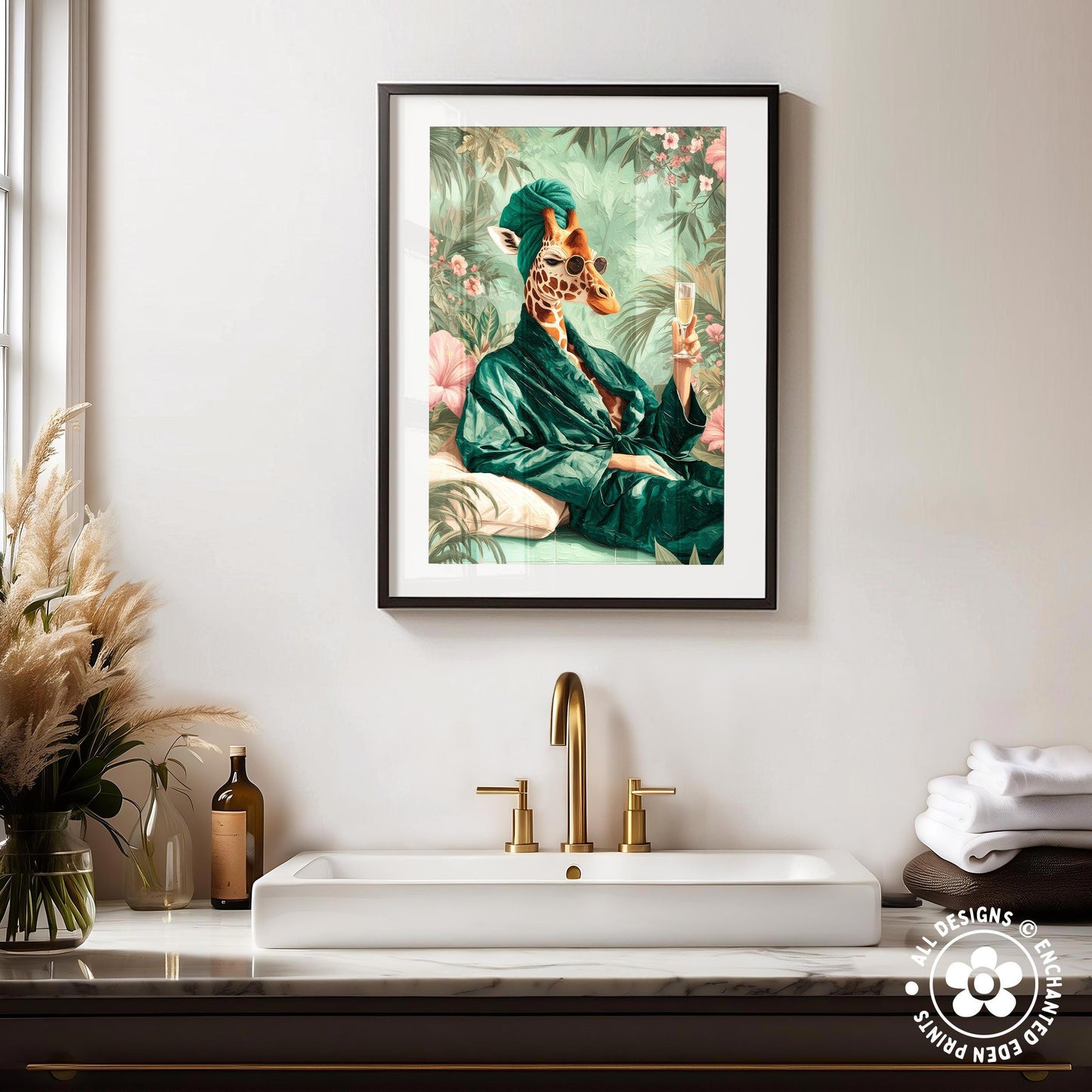 a framed painting of a giraffe wearing a green robe and holding a drink, hanging on a wall above a white sink with gold faucets.