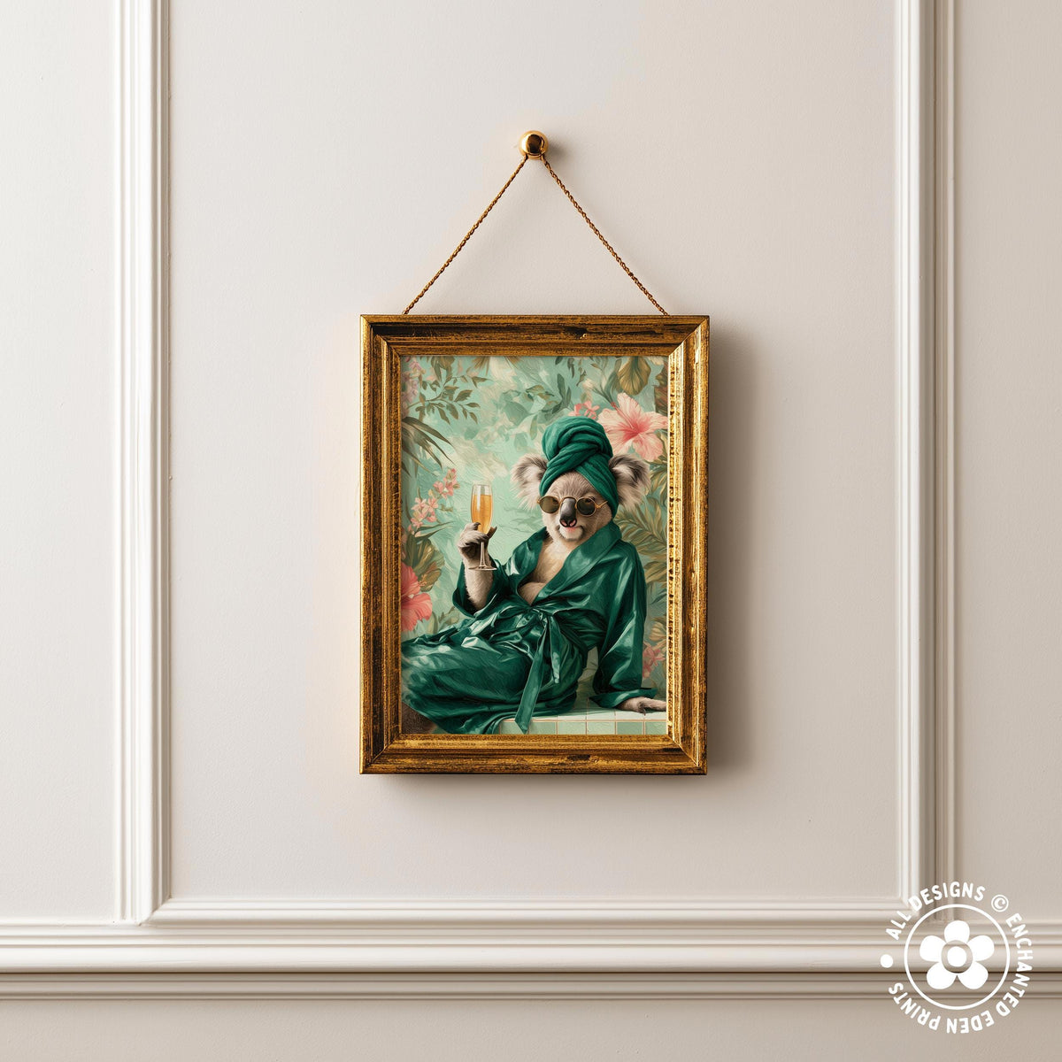 A framed painting of a koala wearing a green robe and holding a glass of champagne is hanging on a white wall.