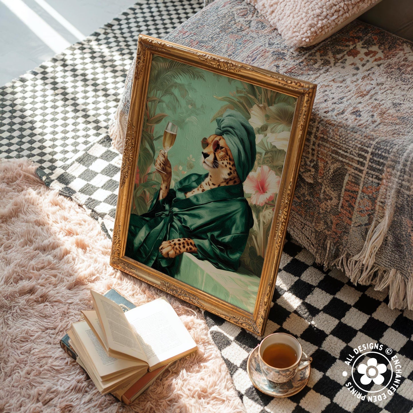 a framed painting of a leopard wearing a green robe and holding a glass of wine, placed on a checkered rug next to a stack of books and a cup of tea.