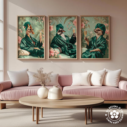 a cozy living room with a pink sofa and a wooden coffee table. Above the sofa, there are three framed pictures of animals, including a giraffe, a penguin, and a cat, all dressed in green robes and holding drinks.