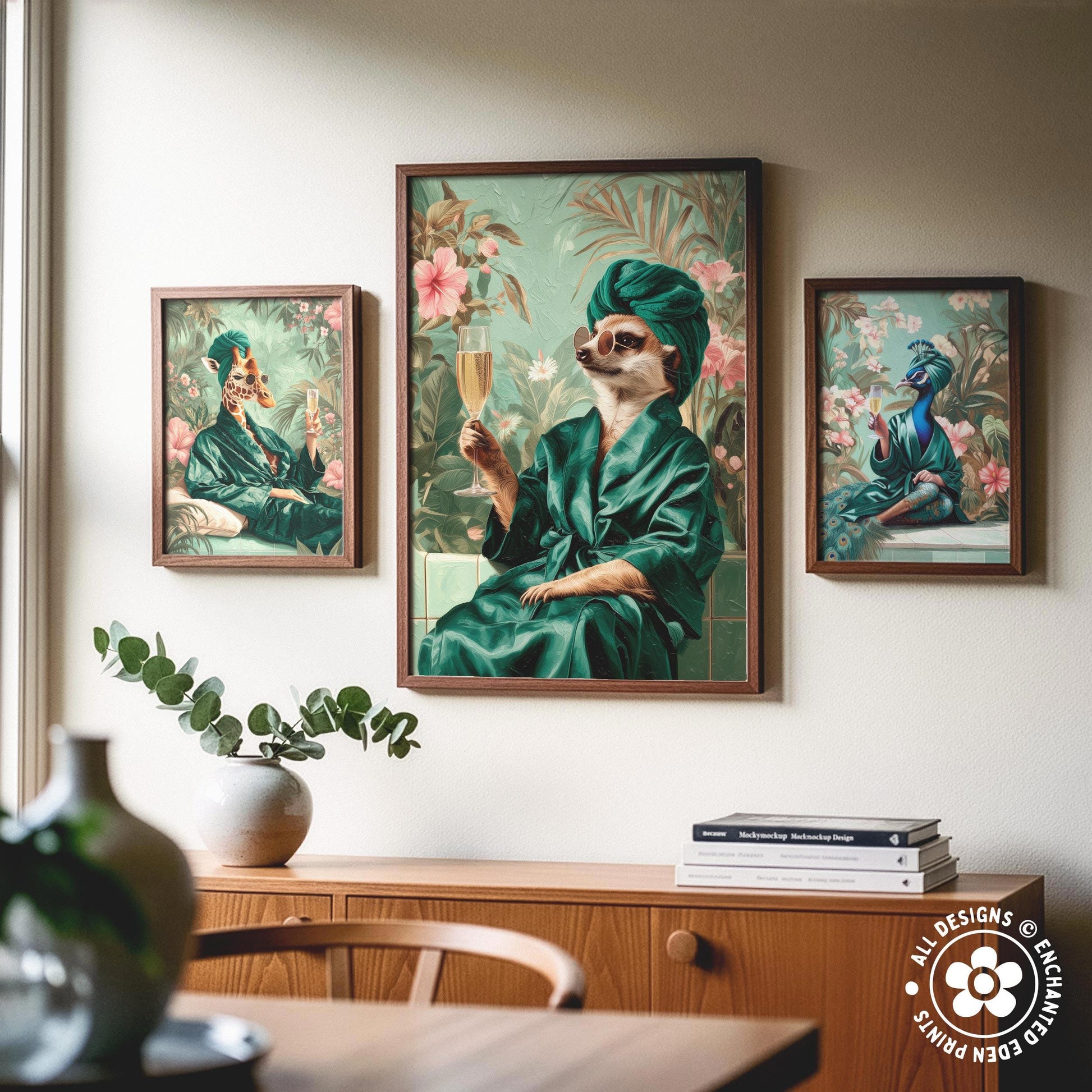 a wooden cabinet with a vase of greenery and a stack of books on top. Above the cabinet, there are three framed paintings depicting animals in various outfits, including a cat in a green robe and a bird in a green outfit.