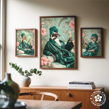 three framed paintings of a duck wearing a green robe and holding a glass of wine, set against a floral background. The paintings are hung on a wall above a wooden cabinet, which has a vase and some books on it.