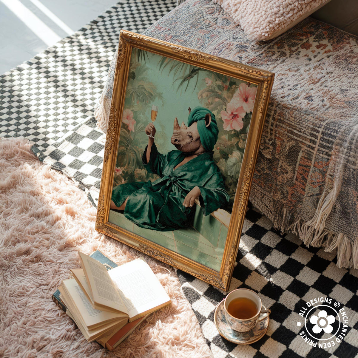 a framed painting of a rhinoceros wearing a green robe and holding a wine glass, sitting on a rug next to a stack of books and a cup of tea.