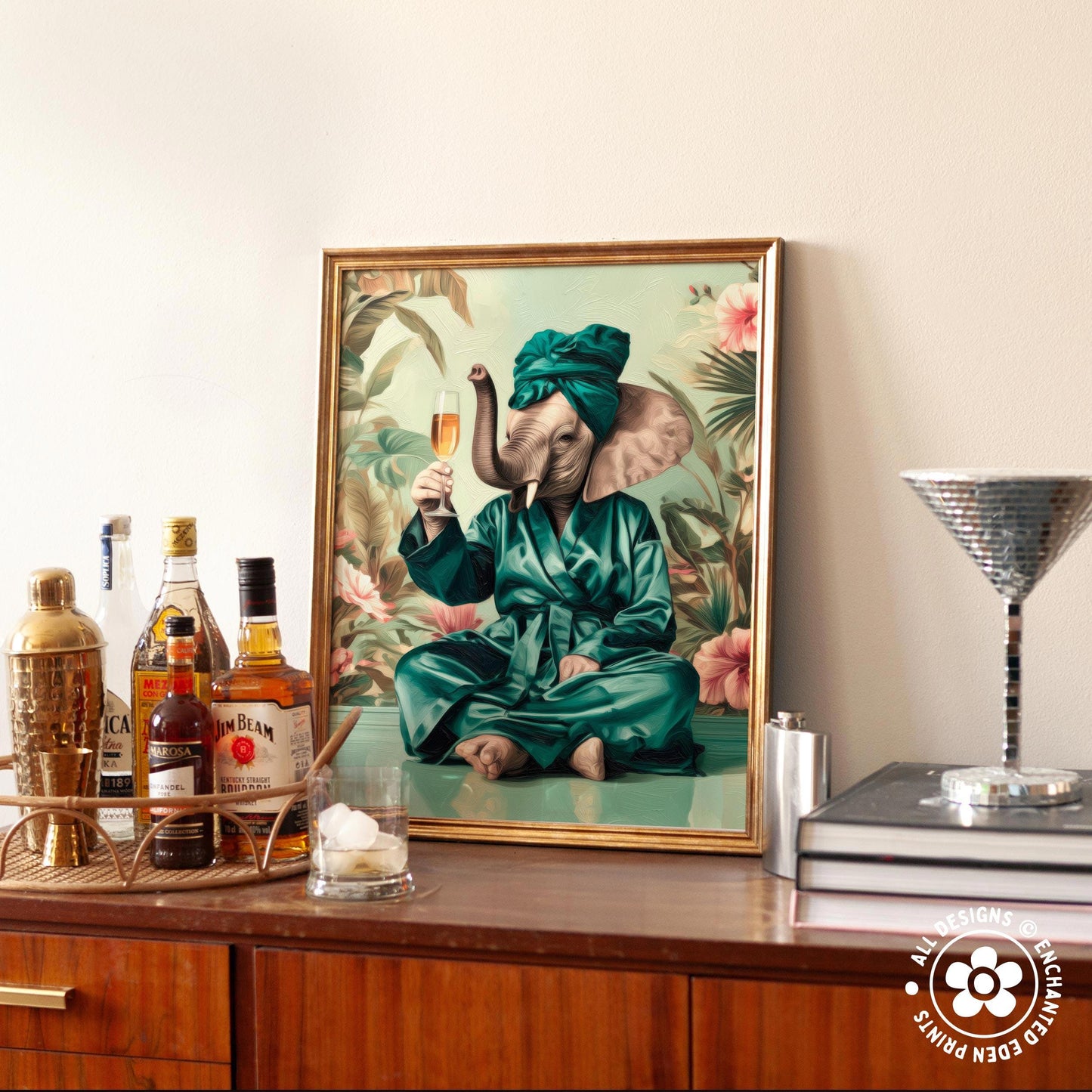 a framed painting of an elephant dressed in a green robe and holding a glass of champagne, sitting on a table surrounded by various bottles of alcohol.