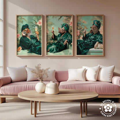 a living room with a pink sofa and a wooden coffee table. Above the sofa, there are three framed pictures depicting animals in green robes, each holding a glass of wine.
