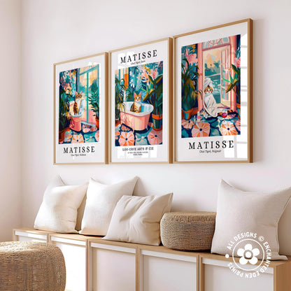 three framed prints of the same artwork, each depicting a cat in a different setting, arranged on a wall above a bench with pillows.