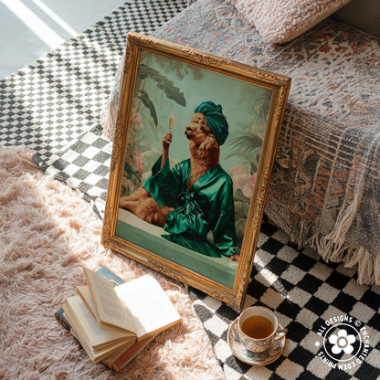 a framed painting of a person in a green robe holding a glass of wine, sitting on a bed with a checkered blanket. Next to the painting, there is a stack of books, a cup of tea, and a small plant.