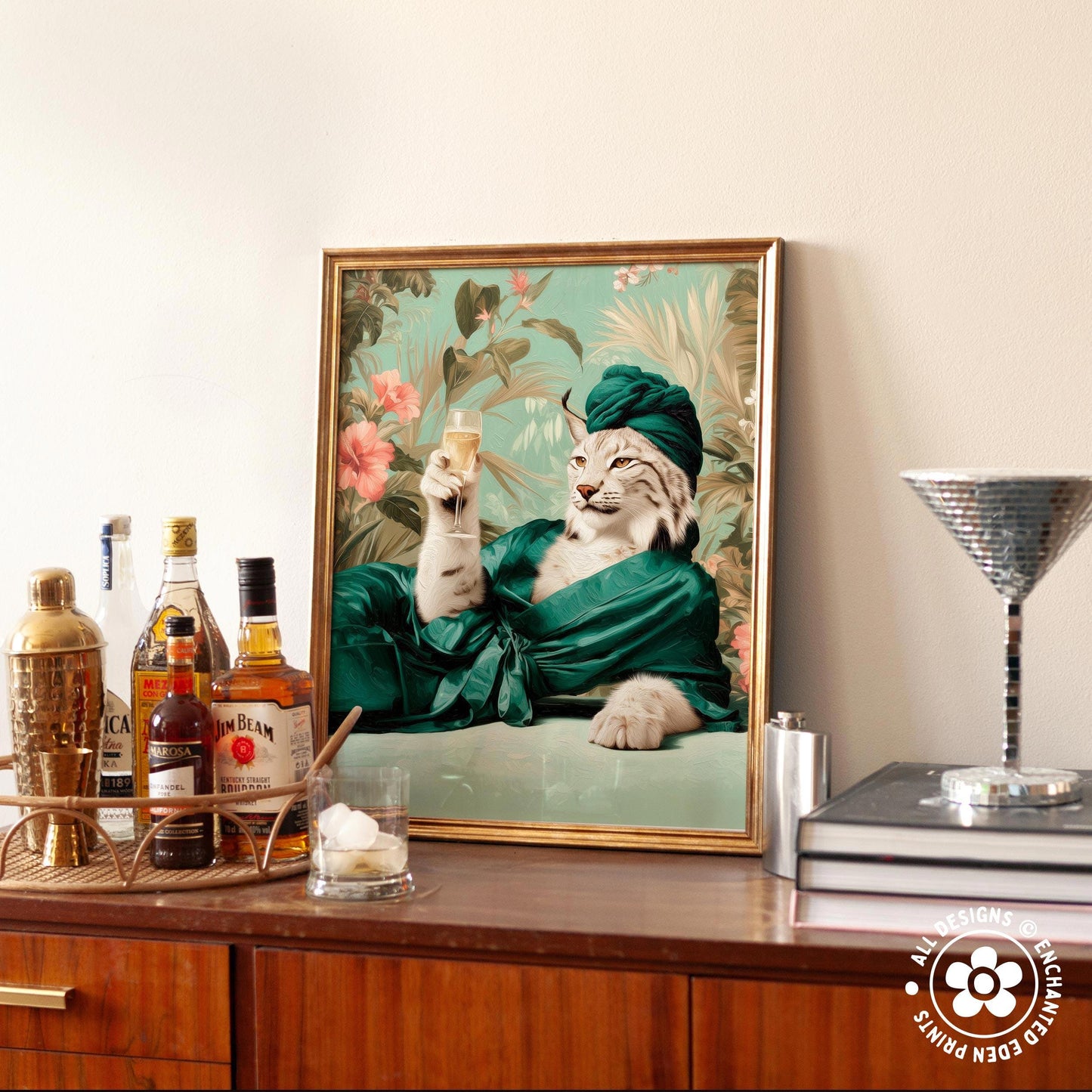 A framed picture of a cat wearing a green robe and holding a glass of wine, sitting on a wooden surface next to various bottles of alcohol.