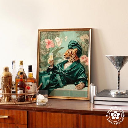 a framed painting of a leopard wearing a green robe and holding a champagne glass, surrounded by various bottles of alcohol and a cocktail shaker on a wooden surface.