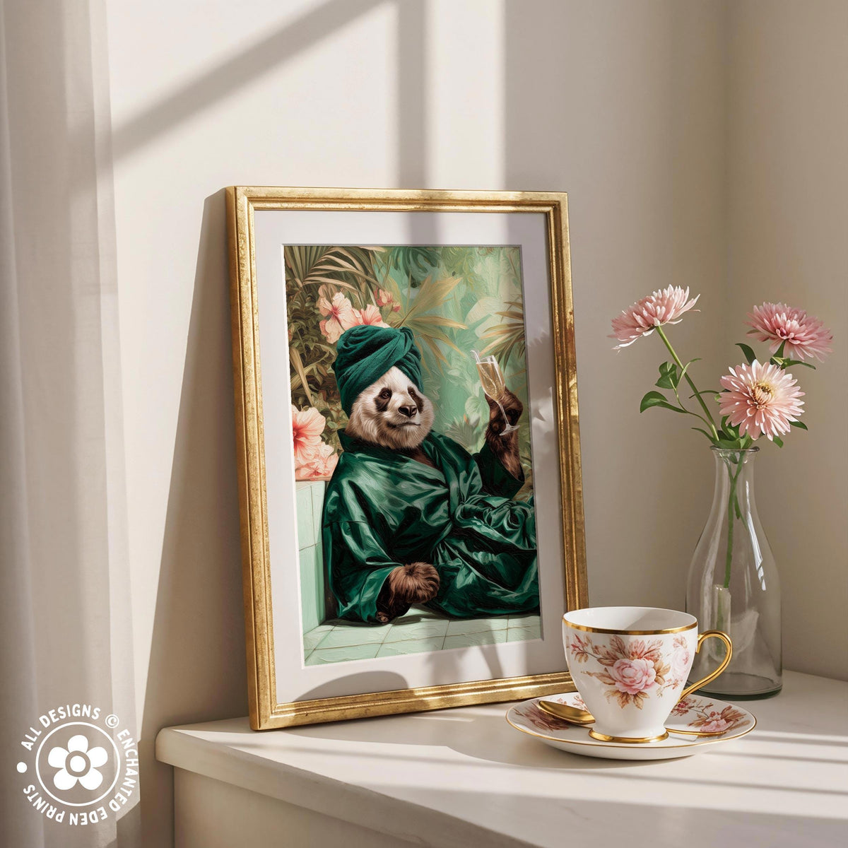a framed painting of a panda wearing a green robe and holding a cup of tea, placed on a white shelf next to a vase of pink flowers and a teacup.