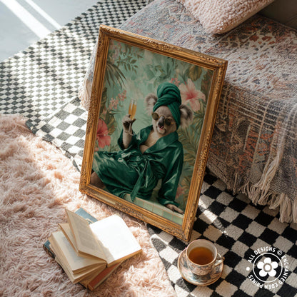 a framed painting of a koala wearing a green robe and holding a glass of wine, sitting on a bed with a checkered blanket. There are also some books and a cup of tea nearby, creating a cozy and relaxing atmosphere.