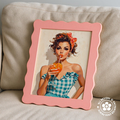 A framed painting of a woman in a blue and white checkered dress, holding a drink, is displayed on a beige couch.