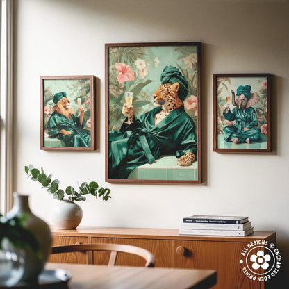 a collage of three framed artworks depicting animals in green robes, including a lion, a leopard, and an elephant, all holding champagne glasses. The artworks are displayed on a wall above a wooden cabinet, which also has a vase and some books on it.