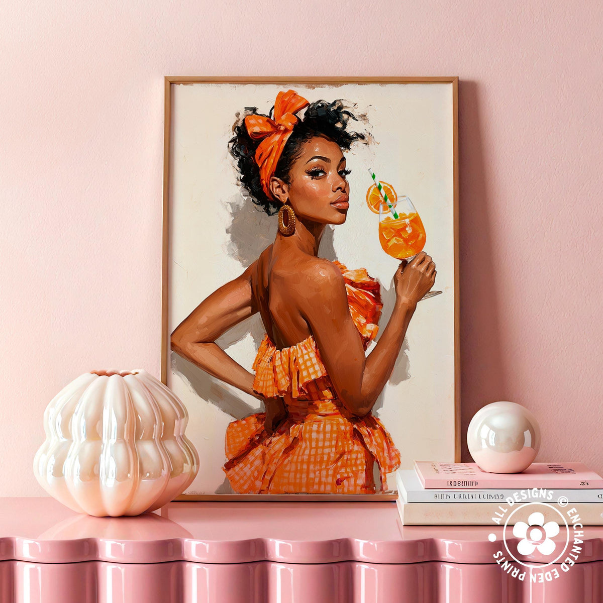 a framed painting of a woman in an orange dress holding a glass of orange juice, with a white vase and a stack of books on a pink shelf below the painting.