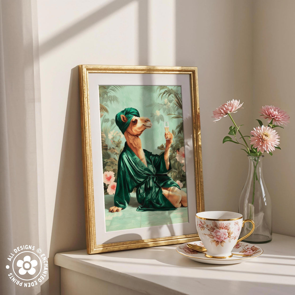 a framed painting of a camel wearing a green robe and holding a glass of wine, placed on a white shelf next to a vase of pink flowers and a cup of tea.