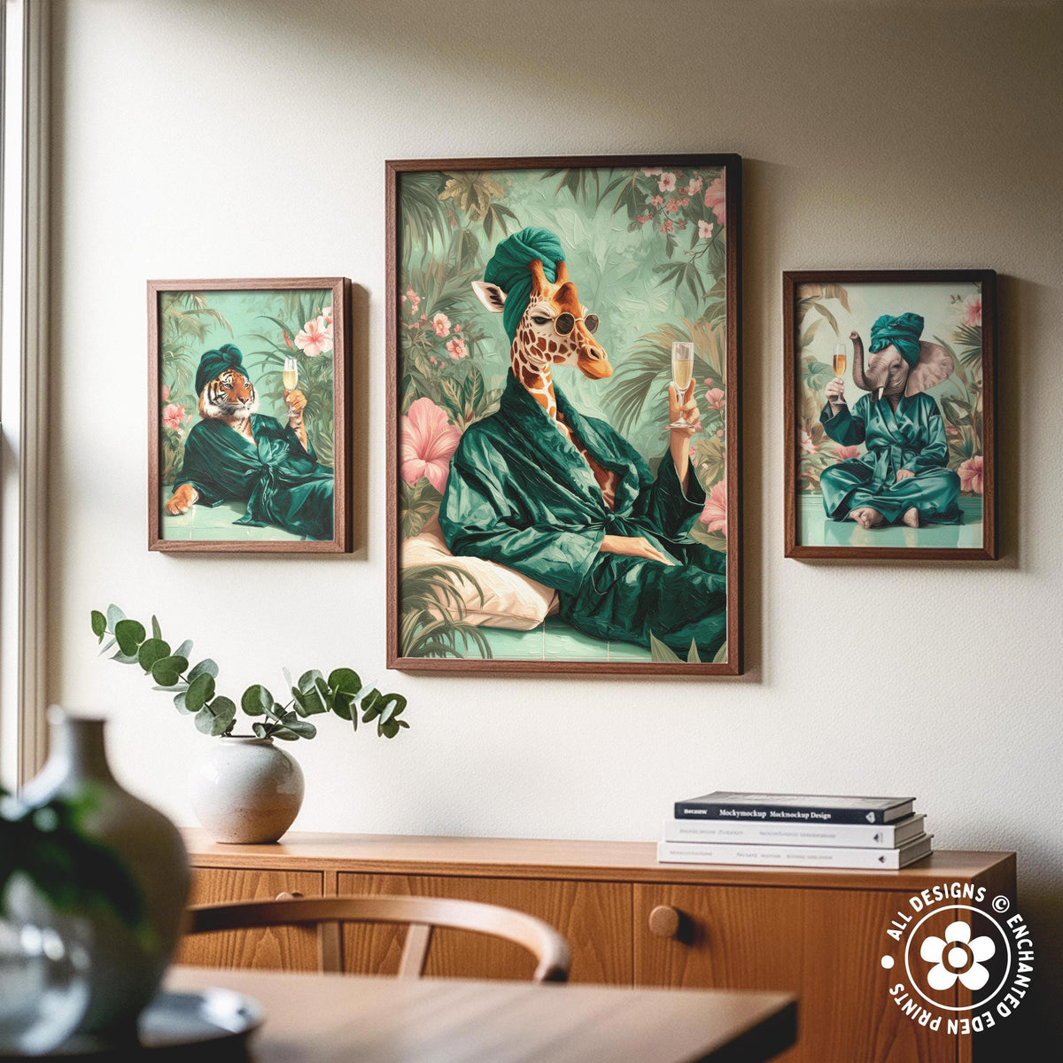 a wooden cabinet with a vase of greenery and a stack of books on top. Above the cabinet, there are three framed paintings depicting animals in green robes, including a giraffe, a tiger, and an elephant.