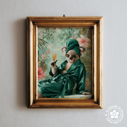 A framed image of a koala wearing a green robe and holding a glass of champagne, set against a floral background.