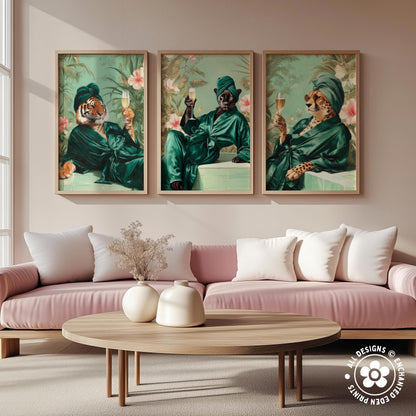 a living room with a pink sofa and a wooden coffee table. Above the sofa, there are three framed paintings depicting animals, including a tiger, a leopard, and a cheetah, all dressed in green and holding wine glasses.