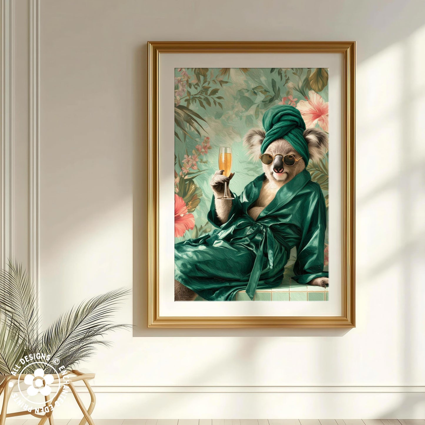 A framed image of a koala wearing a green robe and holding a glass of champagne, set against a floral background.