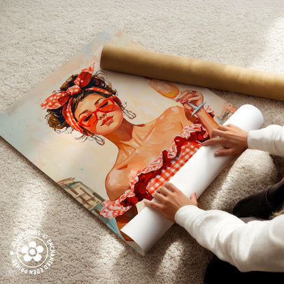 A person is carefully handling a rolled-up poster featuring an illustration of a woman with a red headband and a red and white checkered dress.