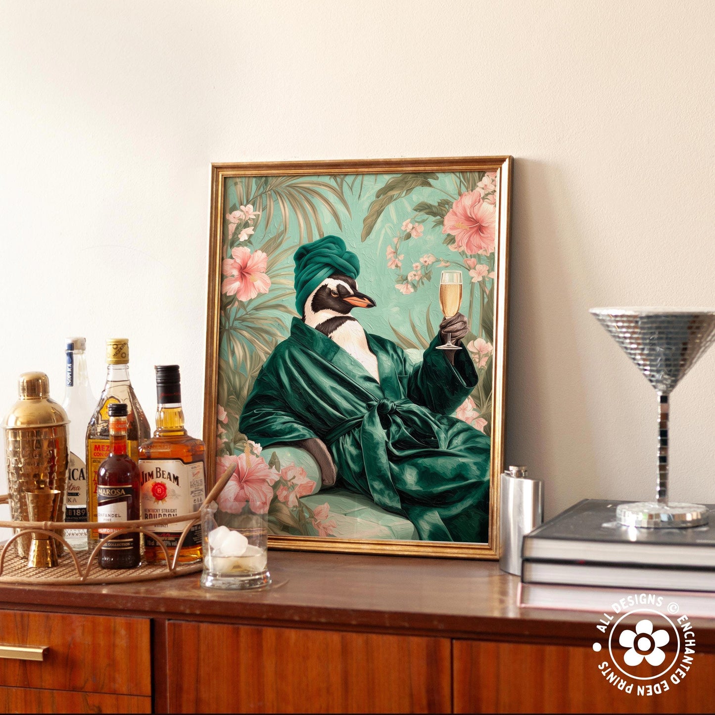 a framed painting of a penguin wearing a green robe and holding a glass of champagne, surrounded by a floral background.