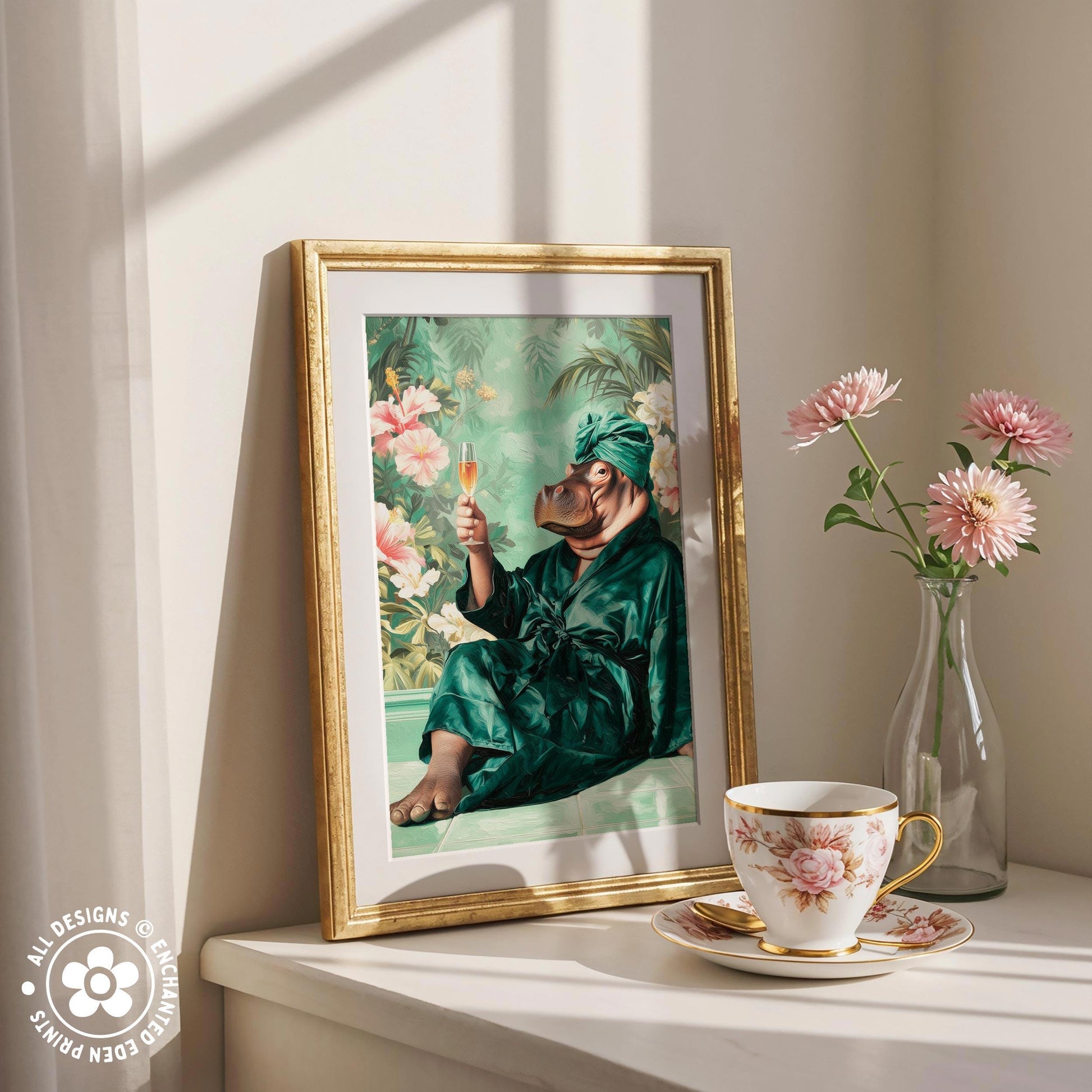 a framed painting of a person in a green robe sitting in a bathtub, holding a glass of champagne, with pink flowers in the background. Next to the painting is a vase with pink flowers, and a cup of tea on a white surface.
