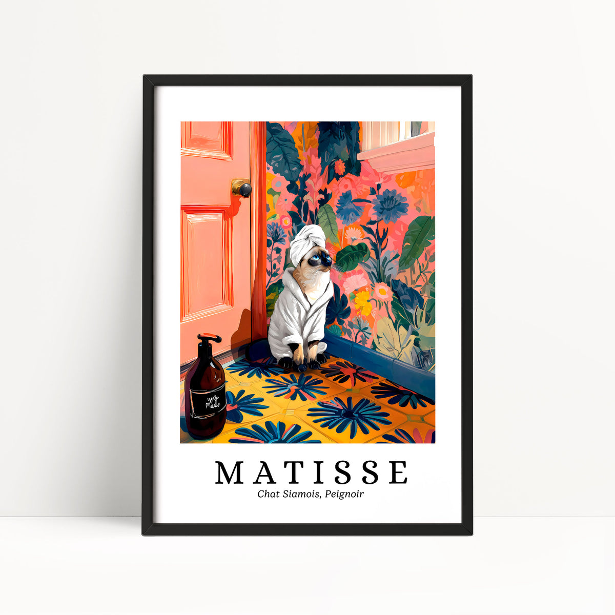 A framed poster featuring a cat wearing a white bathrobe and sitting on a colorful floral rug, with a bottle of shampoo and a pink door in the background.