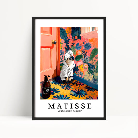 A framed poster featuring a cat wearing a white bathrobe and sitting on a colorful floral rug, with a bottle of shampoo and a pink door in the background.