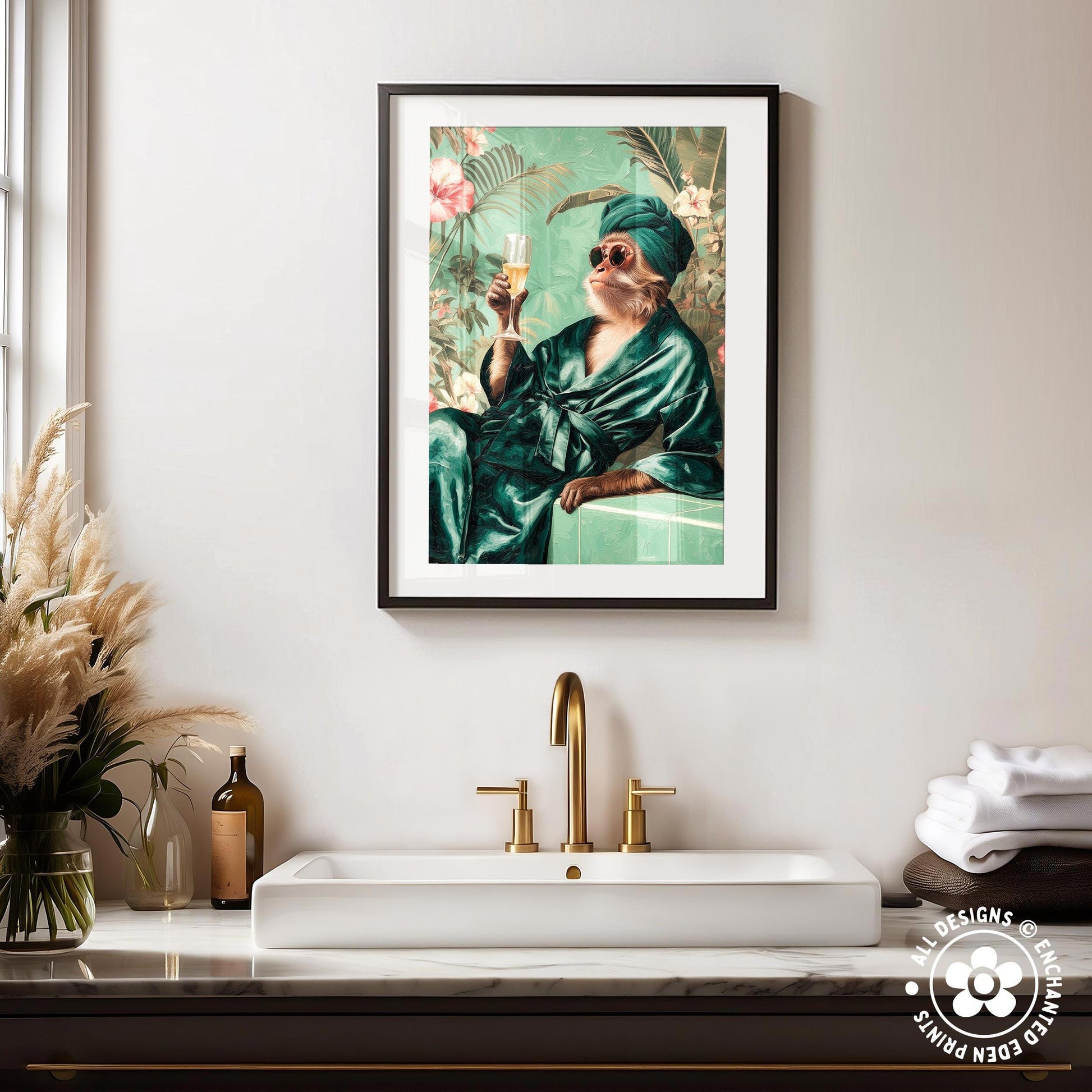 a framed painting of a monkey dressed in a green robe and holding a drink, sitting on a bench in a tropical setting. The painting is hung on a wall above a white sink with a gold faucet.