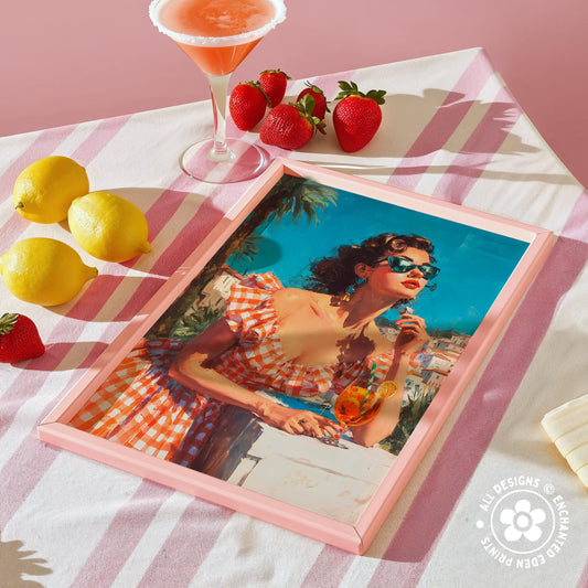 a framed painting of a woman in a red and white checkered dress, holding a drink and surrounded by a pink and white striped tablecloth, lemons, and strawberries.
