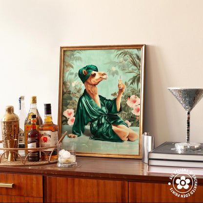 a framed painting of a camel wearing a green robe and holding a glass of wine, surrounded by various bottles of alcohol and a cocktail shaker on a wooden surface.